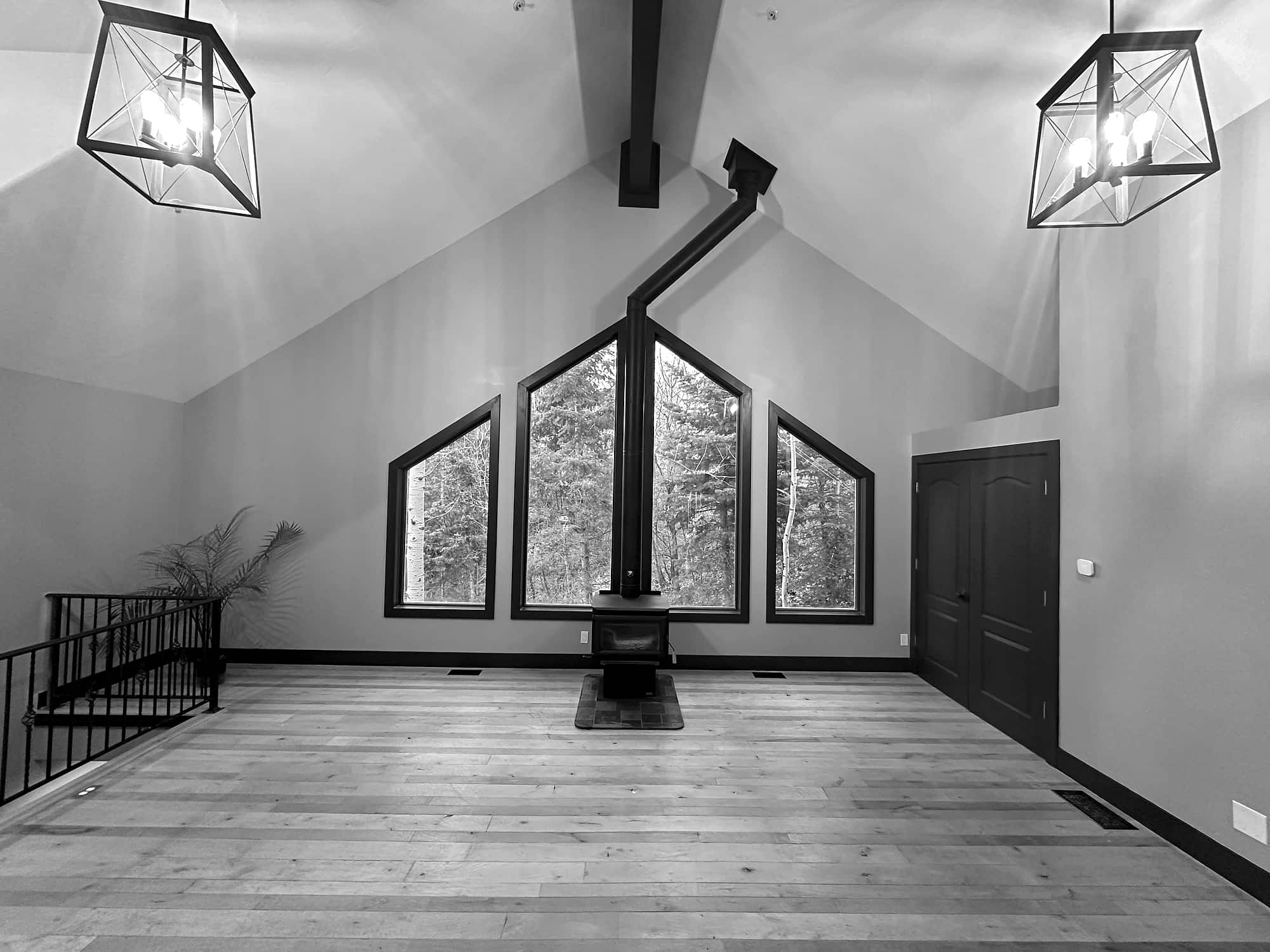 The great room under its vaulted ceiling, wood stove at the centre