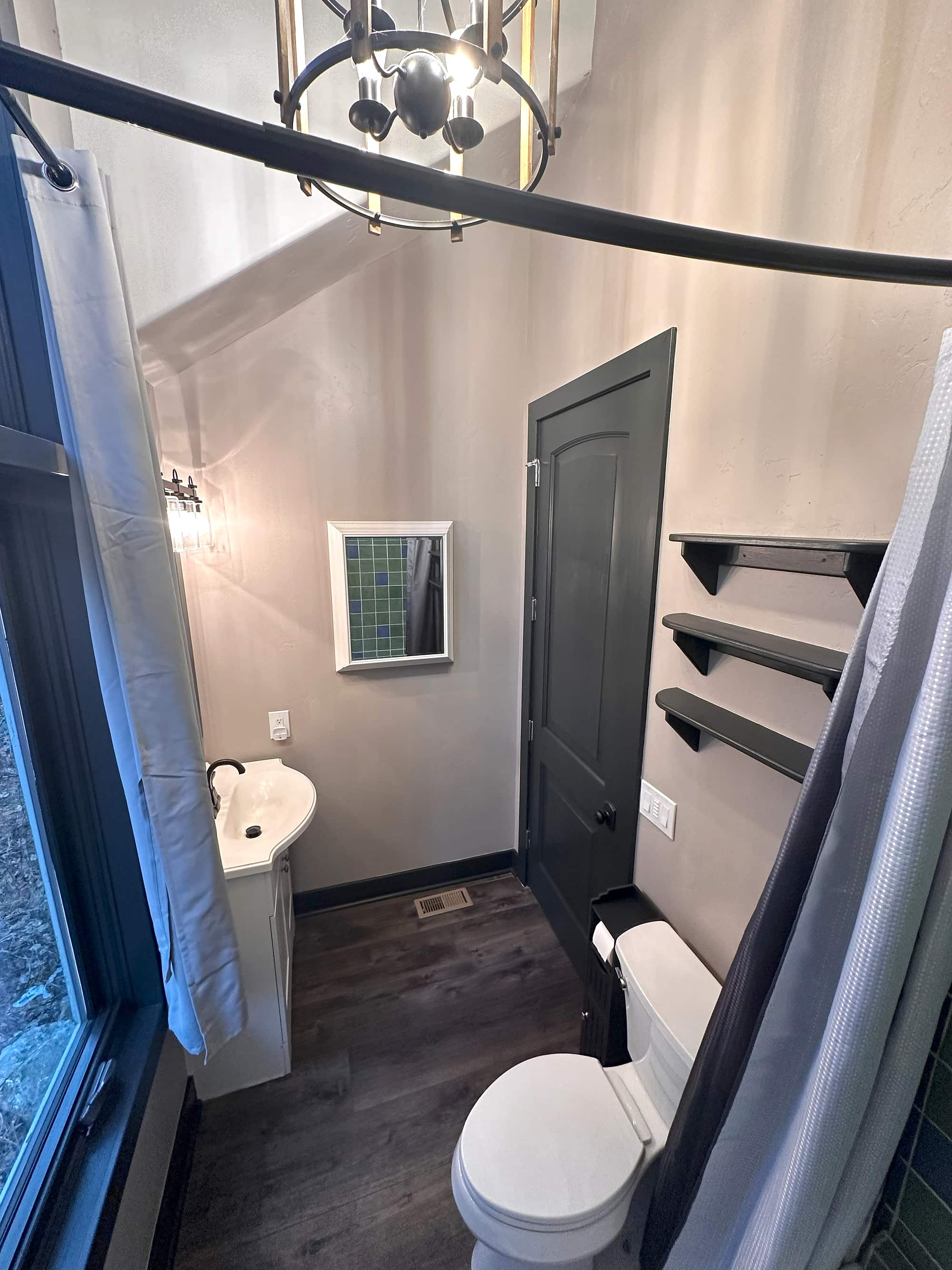 The bath's tub and shower, with the toilet in the foreground
