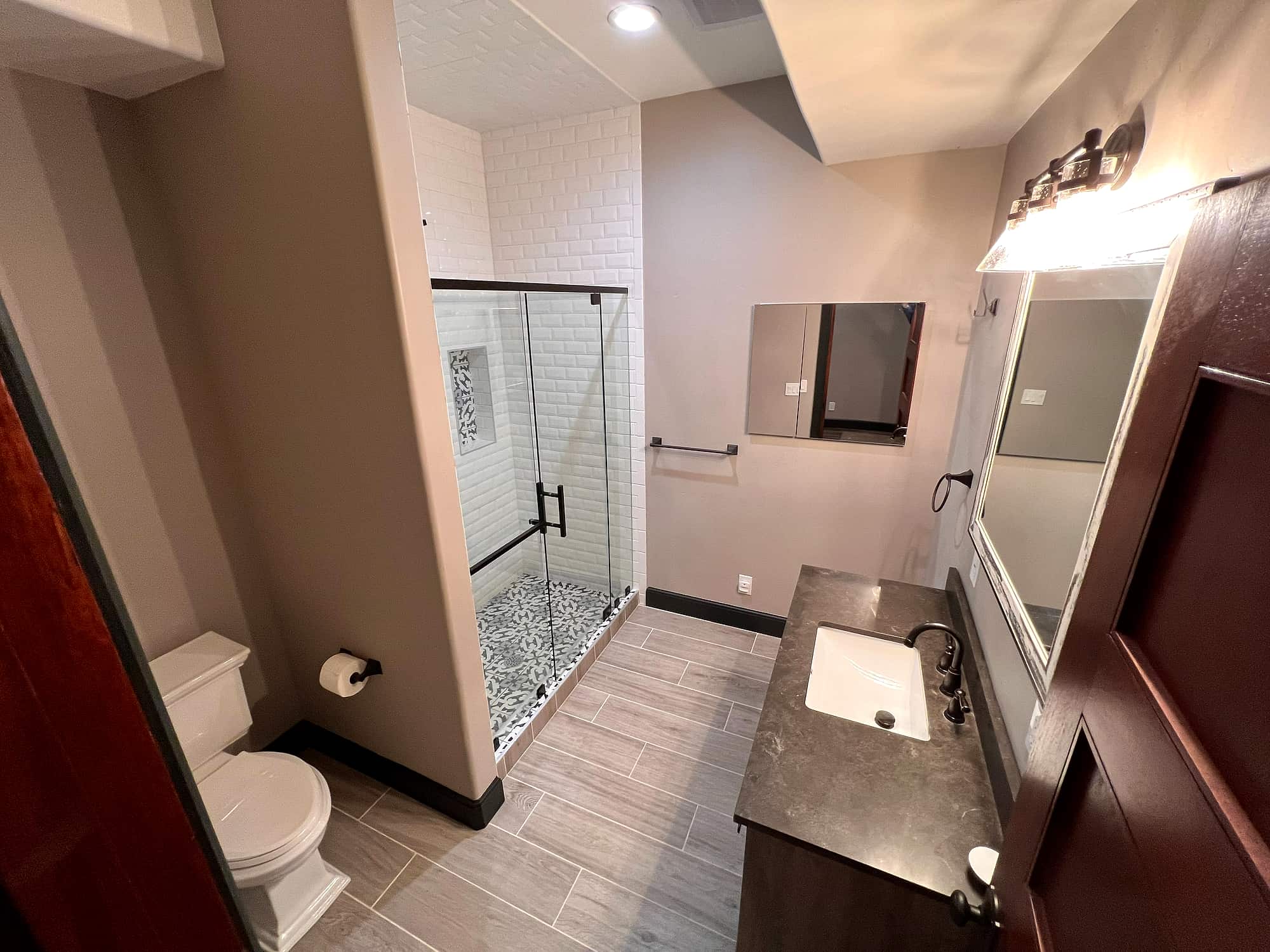 A bath with a subway-tiled glass shower