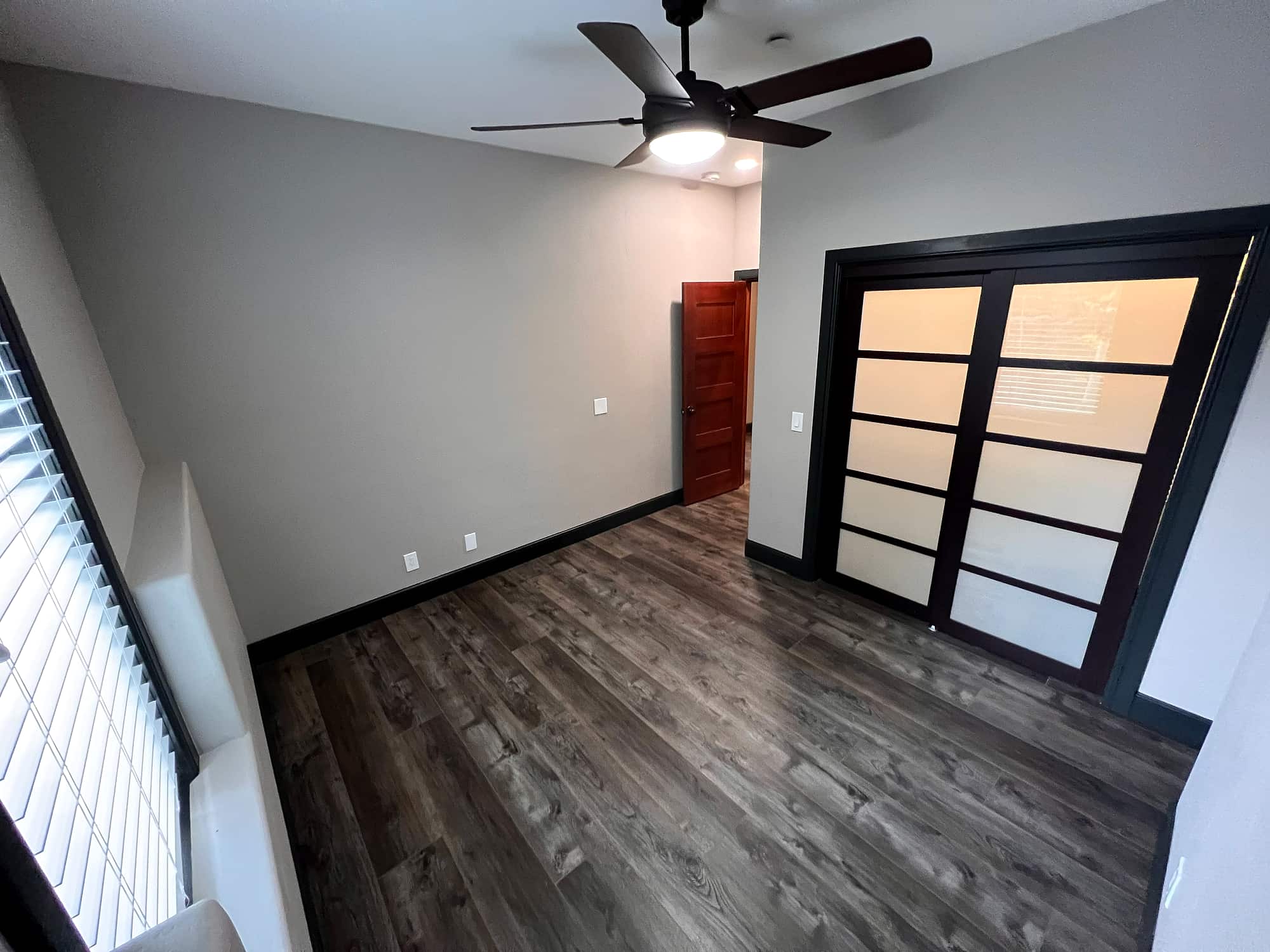 A bedroom with a sliding frosted-glass closet door