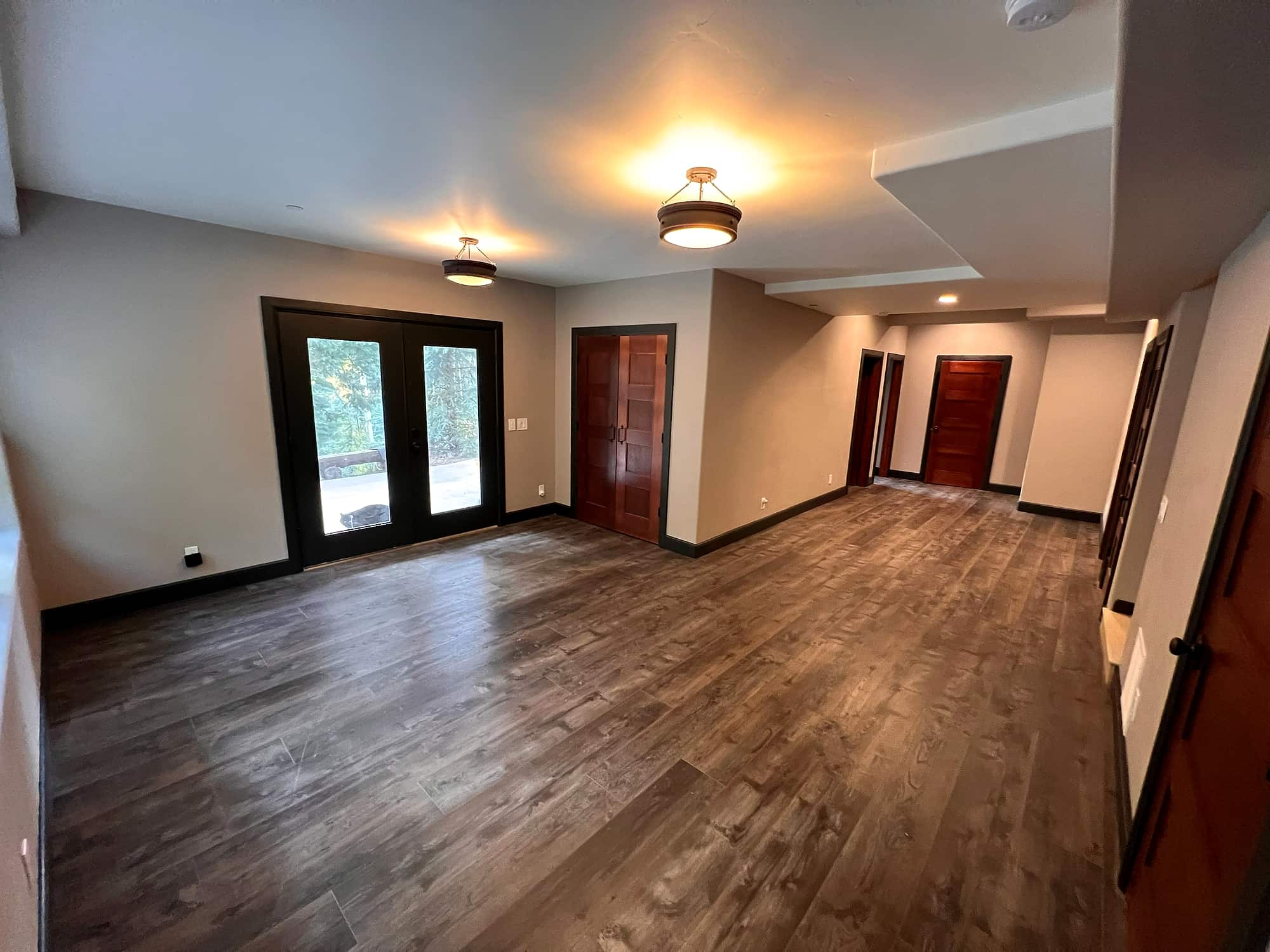 A lower-level hallway with French doors out to the yard