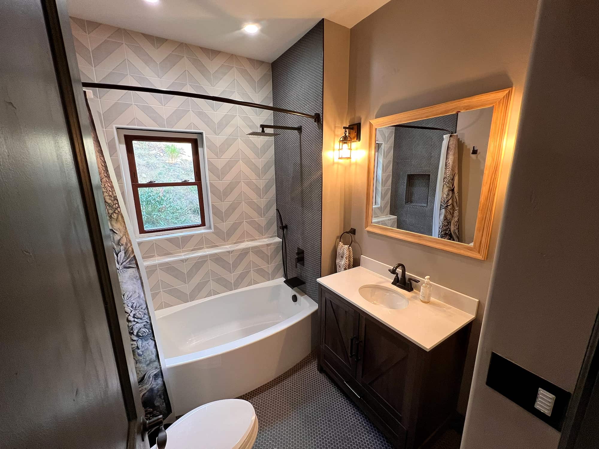 A bath with a soaking tub set in chevron tile
